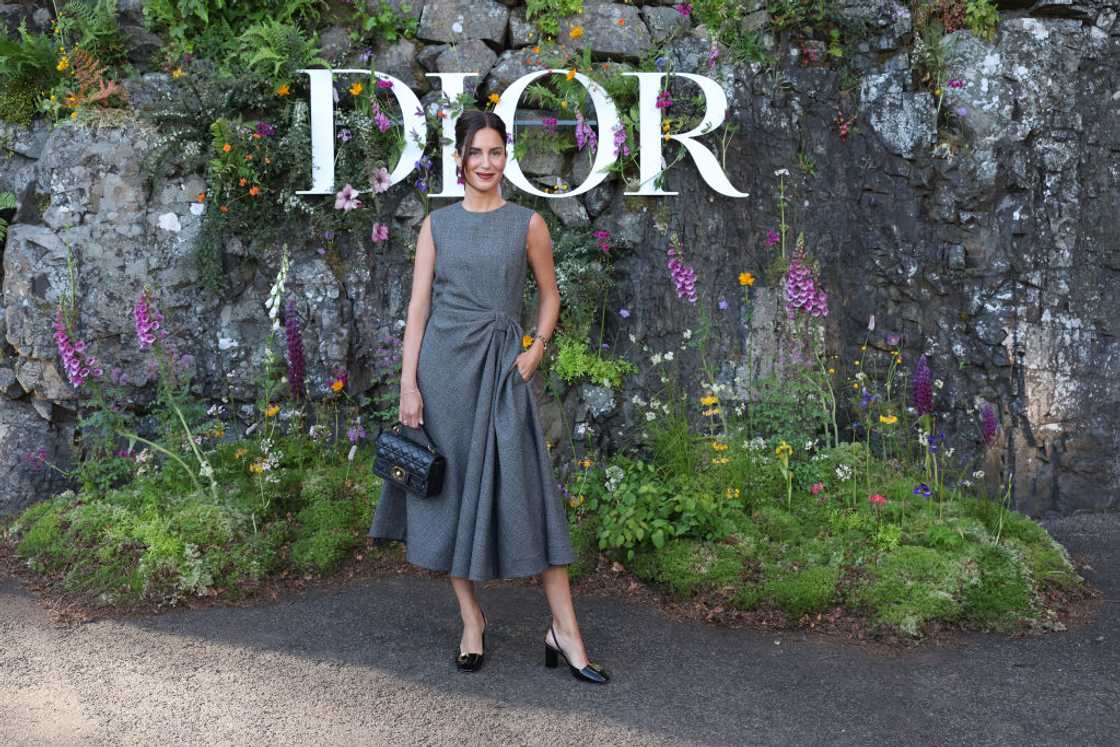 Gala Gonzalez in a grey dress and black bag at the Dior Cruise 2025 at Drummond Castle