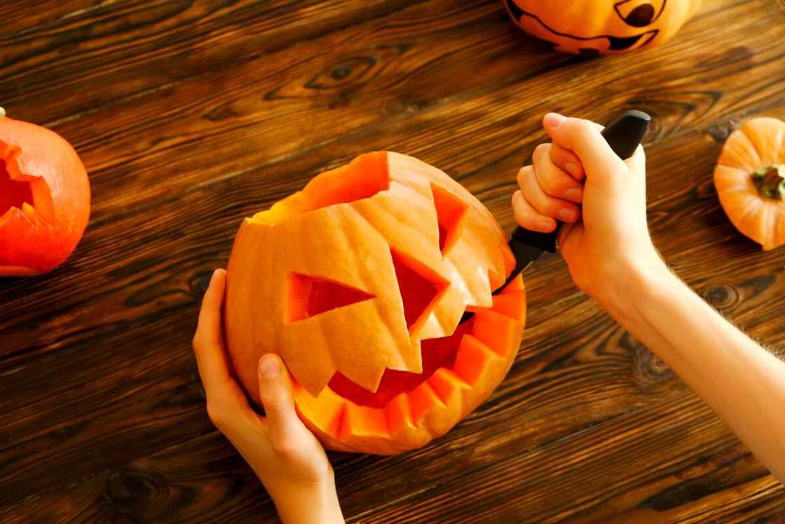 Female preparing all hallows eve Halloween party decorations. Background, copy space.