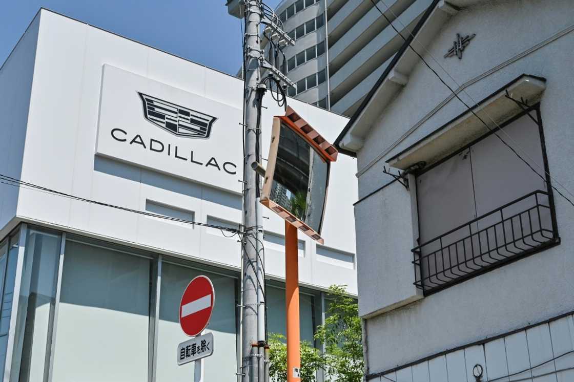 A sign for Cadillac cars is displayed on the outside wall of a car dealership which sells US auto brands Cadillac and Chevrolet in Tokyo A sign for Cadillac cars is displayed on the outside wall of a car dealership which sells US auto brands Cadillac and Chevrolet in Tokyo
