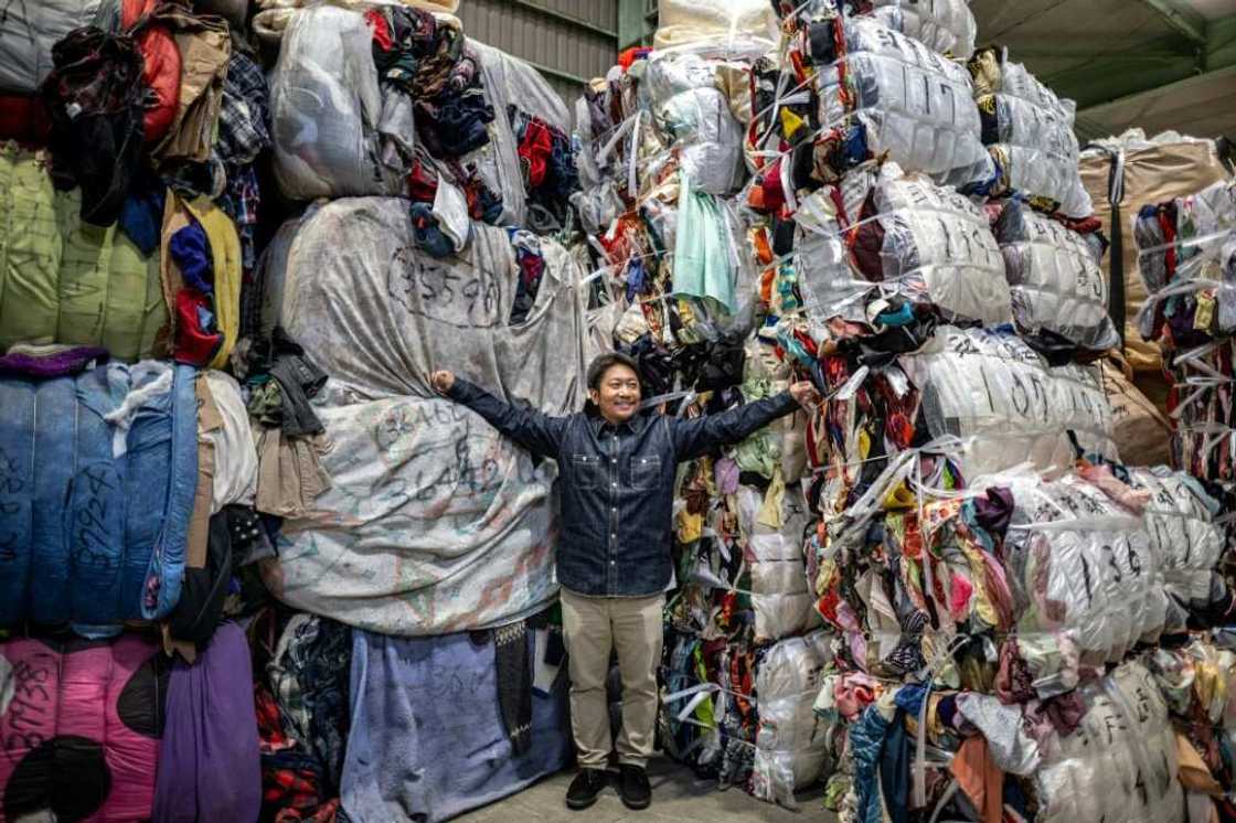 Logistics manager Osamu Ubakai stands with bundles of secondhand clothes at a warehouse in Inashiki city, Ibaraki Prefecture Logistics manager Osamu Ubakai stands with bundles of secondhand clothes at a warehouse in Inashiki city, Ibaraki Prefecture