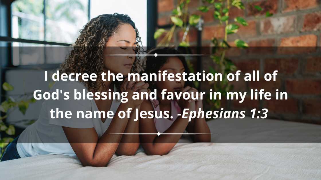 Mother and daughter praying on their knees in their bedroom