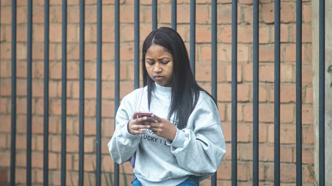 A serious woman typing outdoors A serious woman typing outdoors