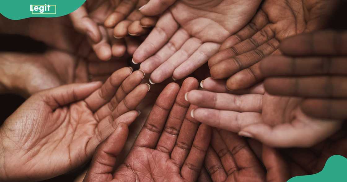A group of people put their hands together as a sign of social cooperation. A group of people put their hands together as a sign of social cooperation.