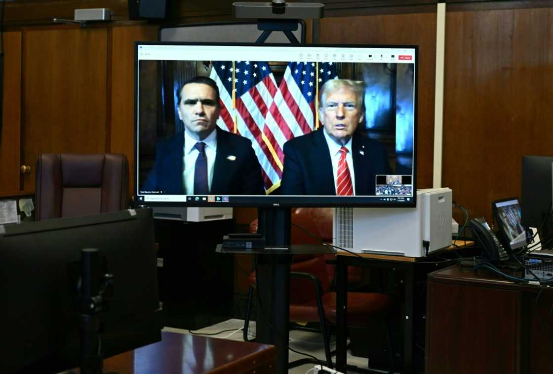 Todd Blanche, attorney for former US President Donald Trump, and US President-elect Donald Trump are seen on the screen at Manhattan criminal court in New York