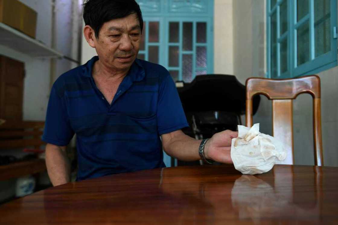 Resident Tran Minh Hoang wrapped his home in netting to keep out the dust, but it still gets in Resident Tran Minh Hoang wrapped his home in netting to keep out the dust, but it still gets in