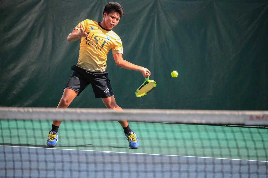 A man in yellow jersey hitting a tennis ball A man in yellow jersey hitting a tennis ball