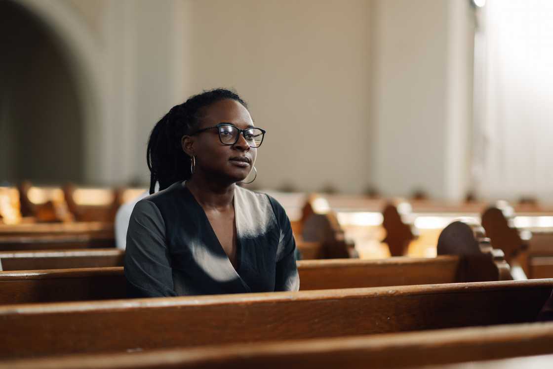 Novels Black woman in a reflective mood in church