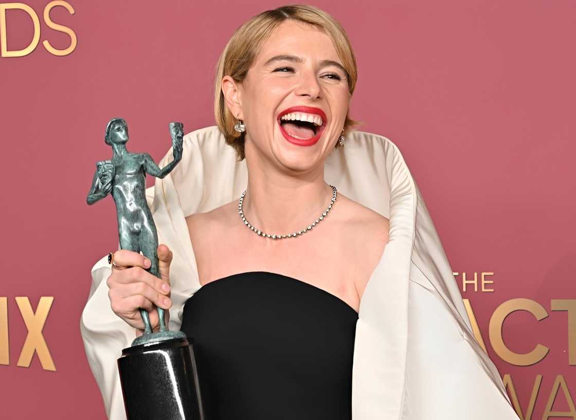 Jessie Buckley posing with her 2026 Actor Awards trophy