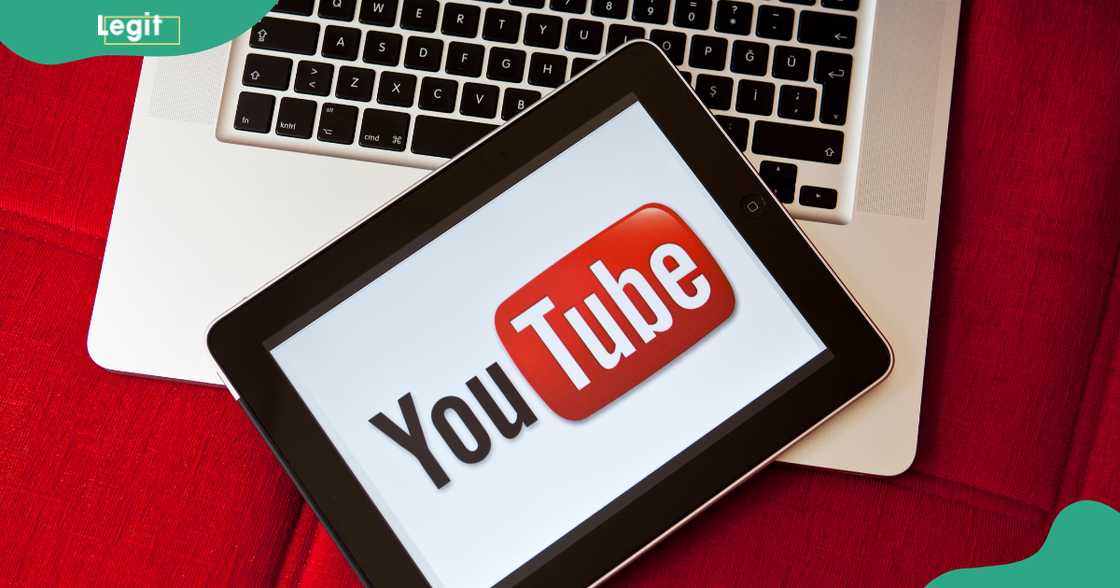 The YouTube logo seen on an iPad resting on an Apple MacBook Pro against a red background. The YouTube logo seen on an iPad resting on an Apple MacBook Pro against a red background.