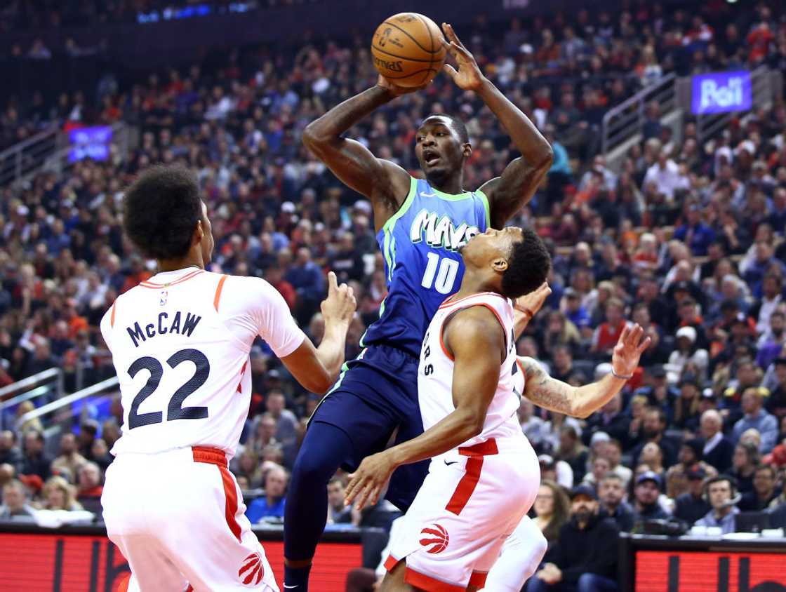 Dorian Finney-Smith, of the Dallas Mavericks, passes the ball as Patrick McCaw and Kyle Lowry of the Toronto Raptors at Scotiabank Arena in Toronto, Canada Dorian Finney-Smith, of the Dallas Mavericks, passes the ball as Patrick McCaw and Kyle Lowry of the Toronto Raptors at Scotiabank Arena in Toronto, Canada