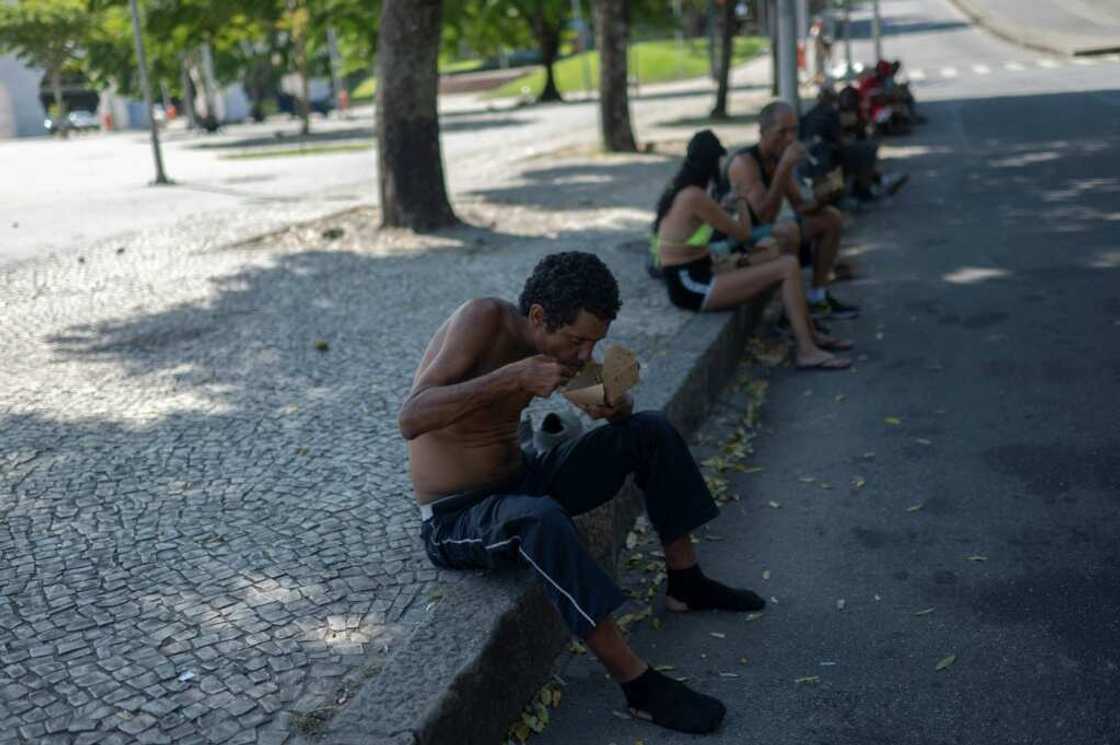 A homeless man eats a meal donated by Brazilian chef Carlos Alberto da Silva, known as Nego Breu, and his team in the Lapa neighborhood in Rio de Janeiro