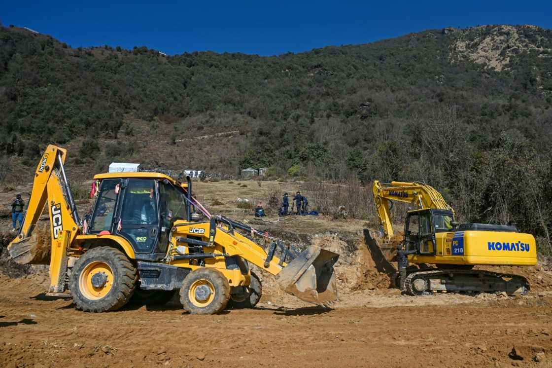 Workers use excavators at the construction site of a cable transportation system, leading to the Pathibhara Devi temple at Taplejung district, in Koshi province of Nepal