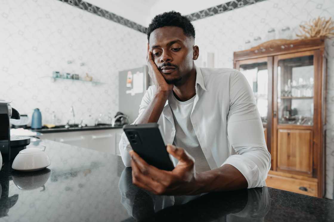 A sad man using a smartphone A sad man using a smartphone