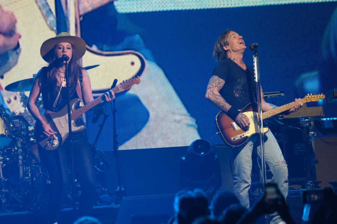 Maggie Baugh and Keith Urban perform at a concert
