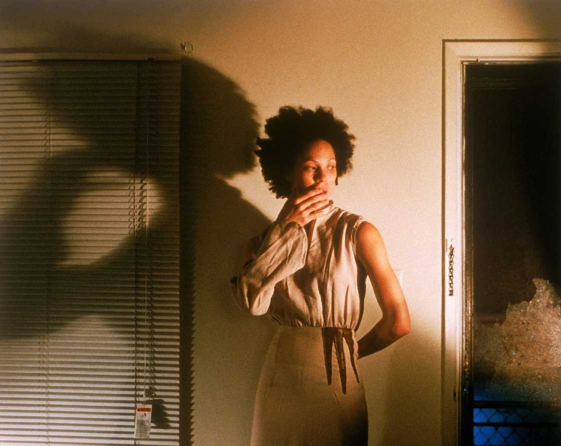 A shocked woman standing next to an open door