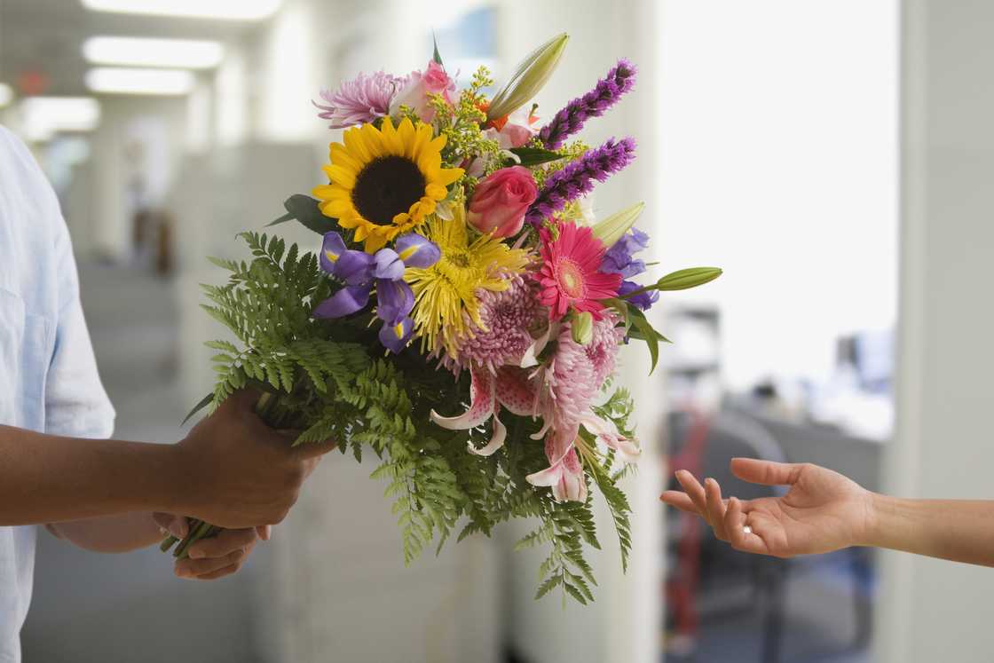 A man holding fresh bouquet of flowers