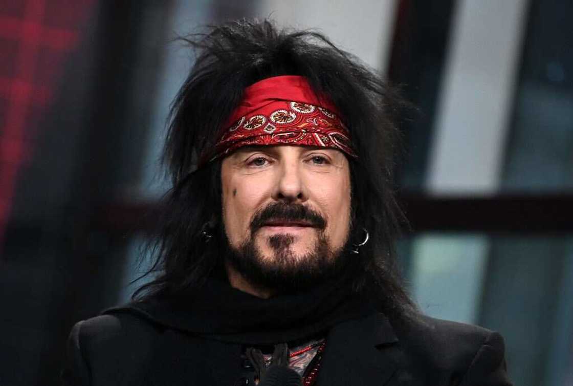 Musician Nikki Sixx in a black outfit and red bandana