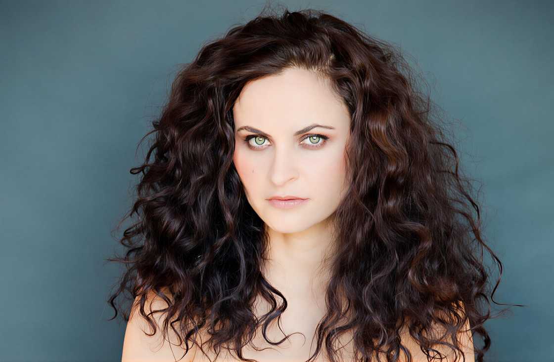 Rain Phoenix poses standing against a blue background Rain Phoenix poses standing against a blue background