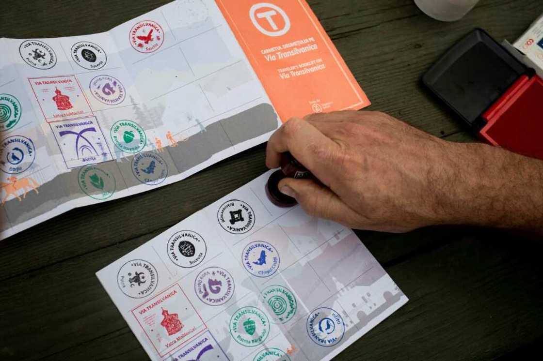 A hiker on the Via Transilvanica receives a stamp in his 'passport' for having completed a stage of the trail