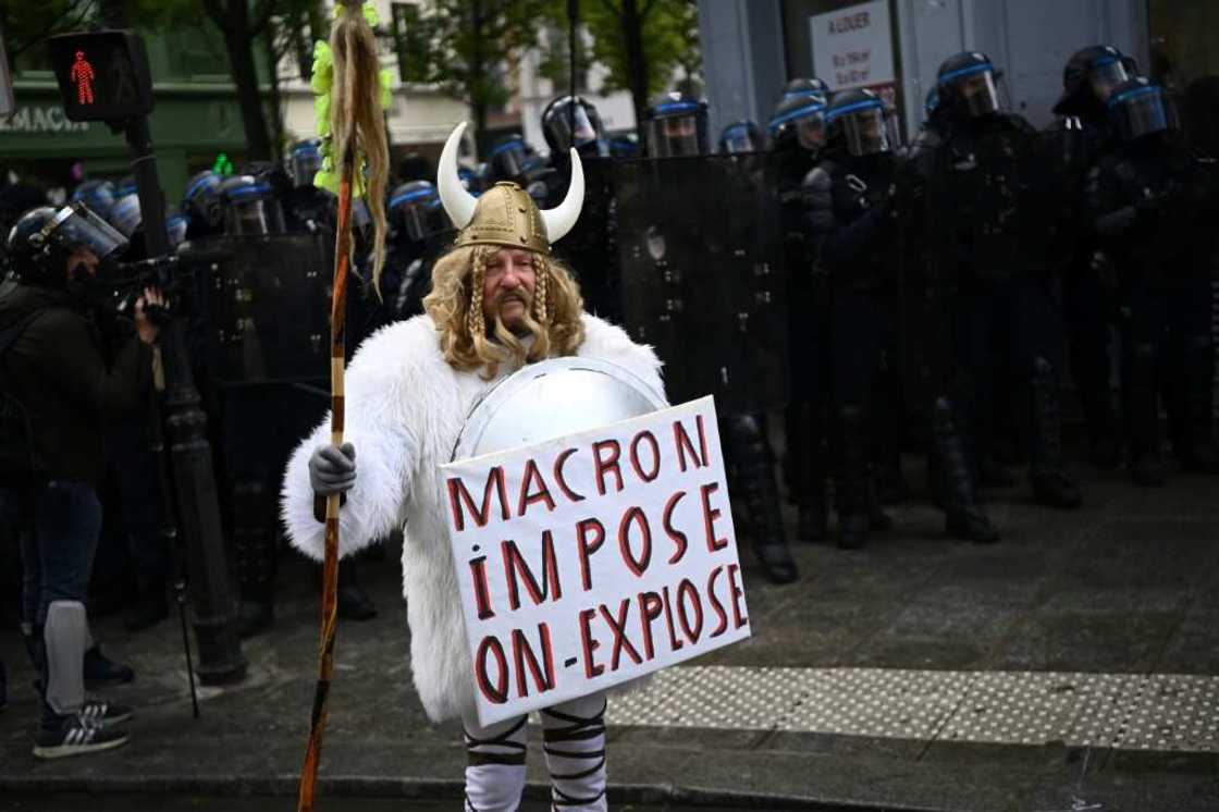 'Macron imposes, we explode,' read one protester's sign in Paris on Thursday 'Macron imposes, we explode,' read one protester's sign in Paris on Thursday