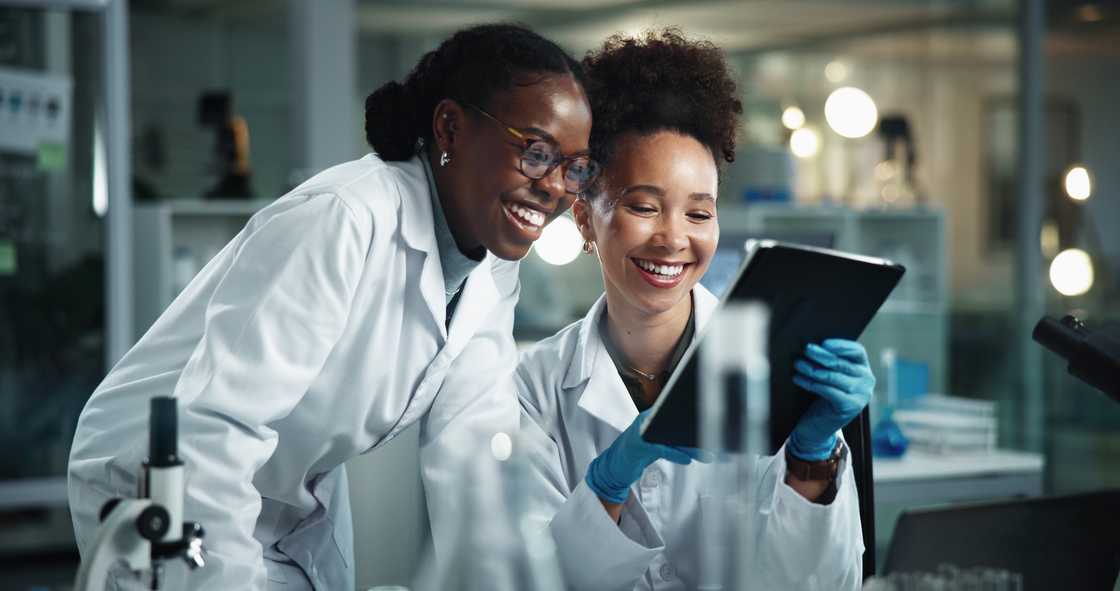 Female scientists using a tablet for research. Female scientists using a tablet for research.