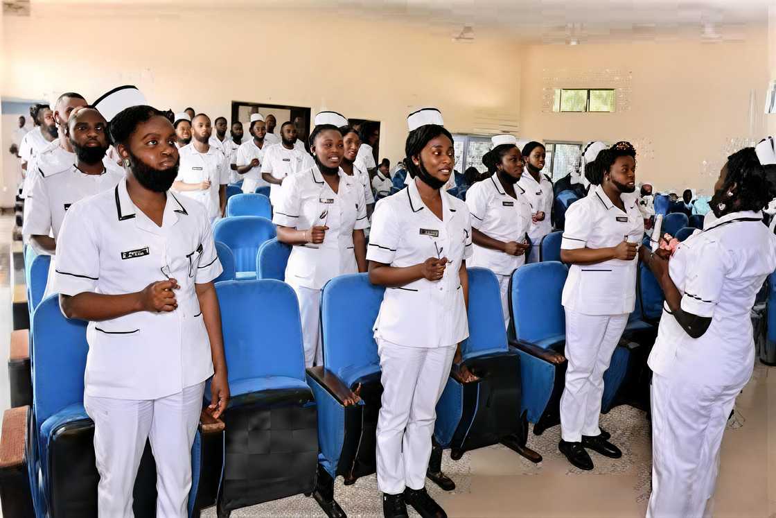 Nursing students stand during a capping or caps and straps ceremony Nursing students stand during a capping or caps and straps ceremony