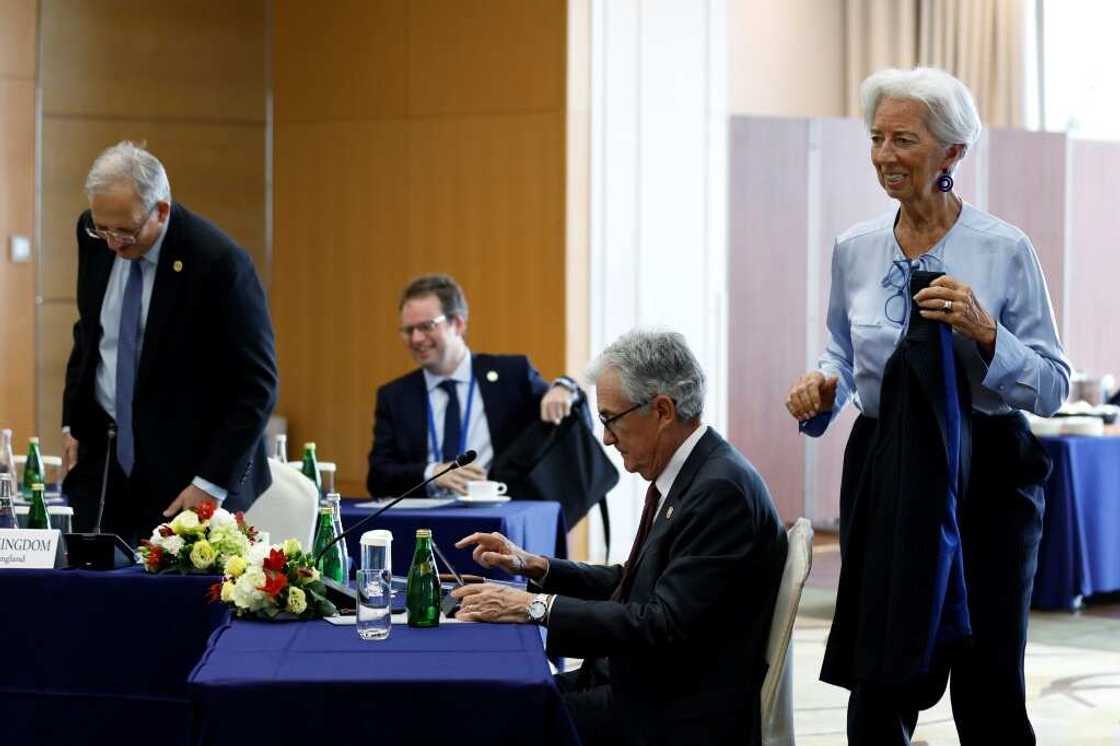 ECB president Christine Lagarde (R) and US Fed chief Jerome Powell (second right) have presided over interest rate hikes aimed at taming inflation