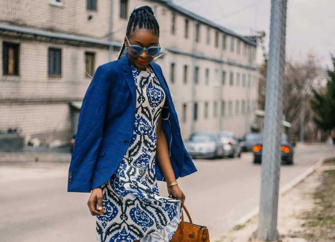 A woman in white and blue floral-dress and a blue blazer