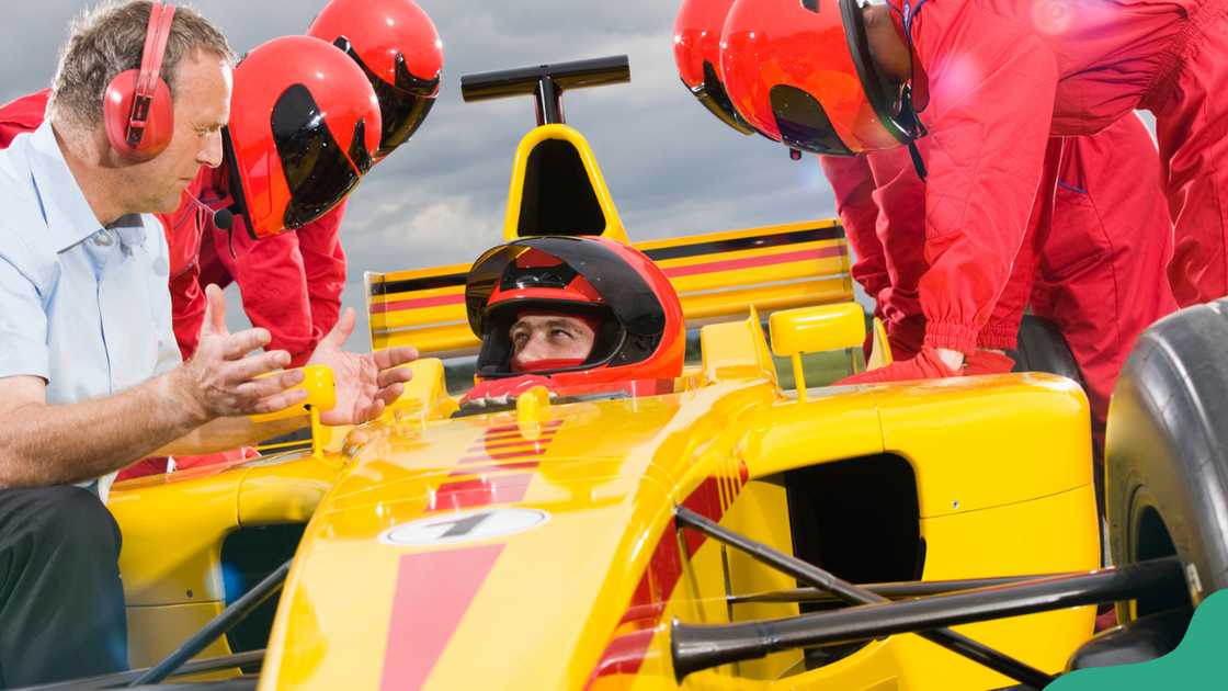 Race Team Leader Discussing Strategy With Racecar Driver Race Team Leader Discussing Strategy With Racecar Driver