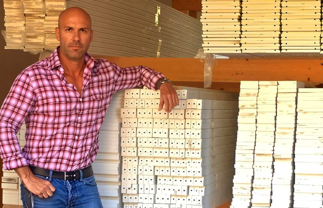 Madison Beer's father, Robert Beer, leans on wooden planks.