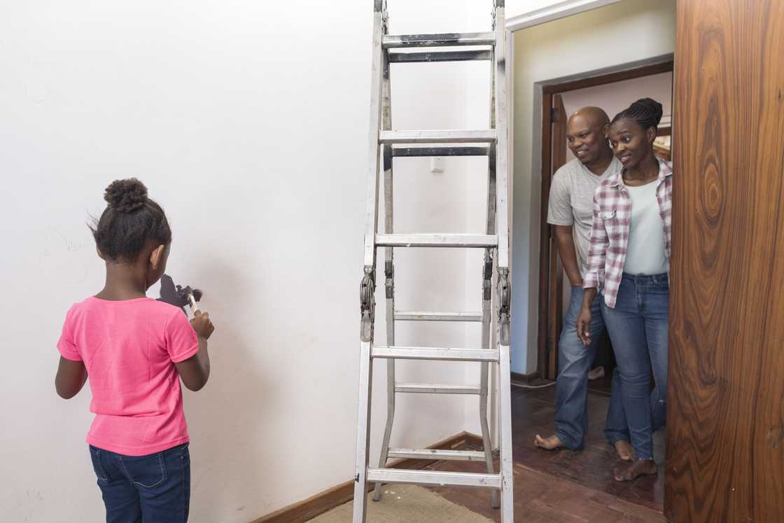 Parents admire their freshly painted children's bedroom.