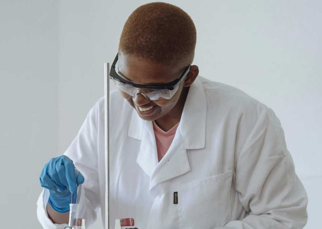 A lady mixing chemicals in a lab