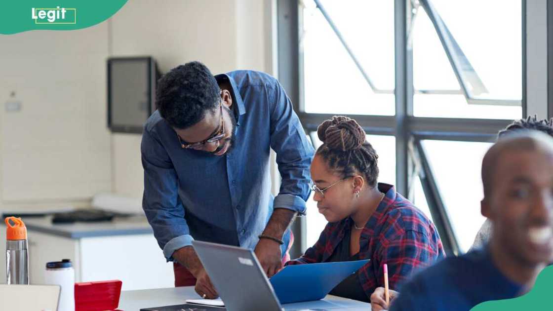 Male teacher guiding a female student in class