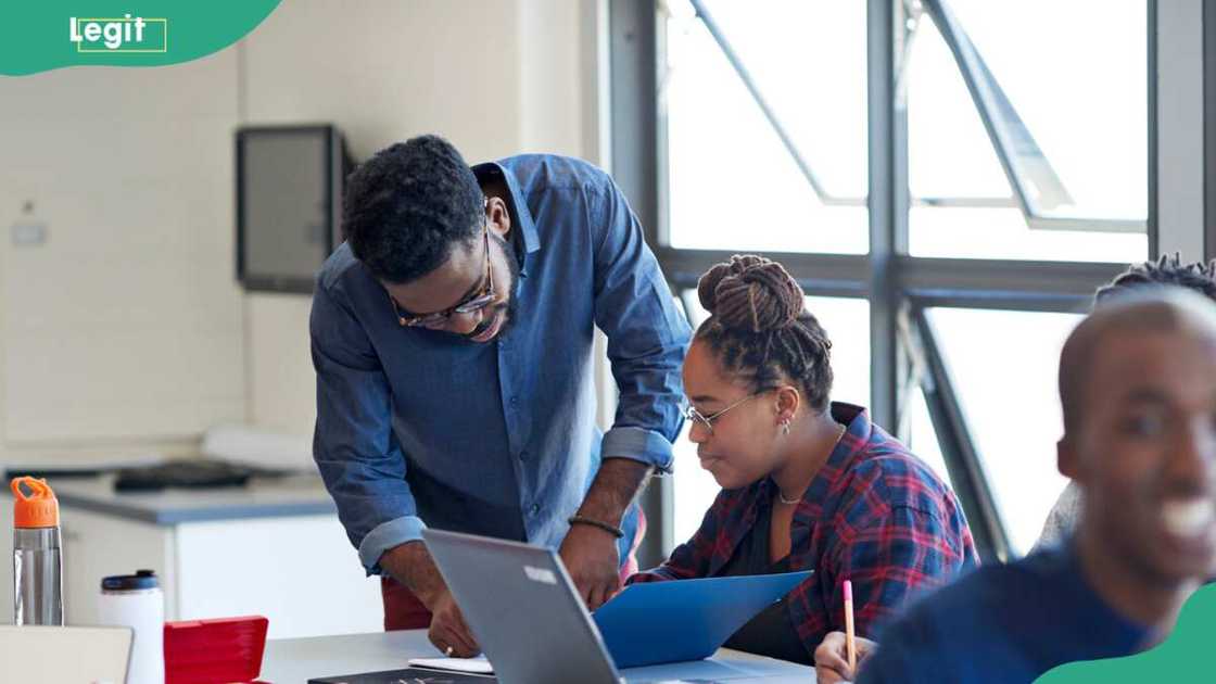 Male teacher guiding a female student in class Male teacher guiding a female student in class