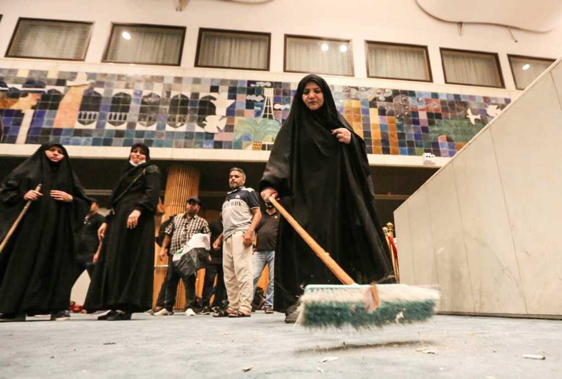 A woman sweeps the floor during the occupation of Iraq's parliament