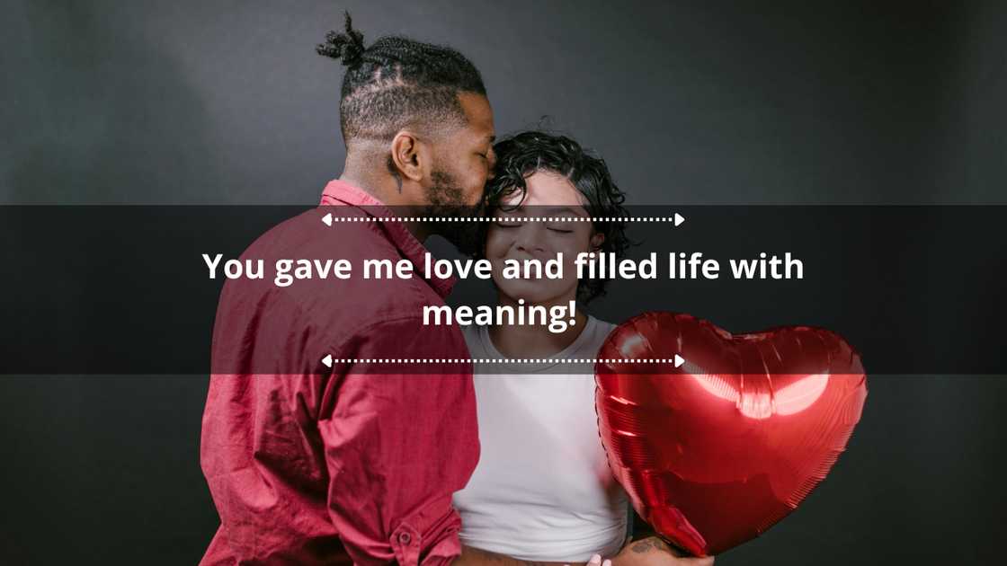 A couple embracing and holding a red balloon.