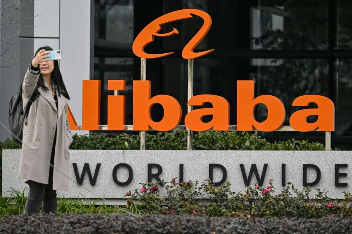 A woman poses for a selfie next to a sign for e-commerce giant Alibaba in the Xuhui district of Shanghai in February A woman poses for a selfie next to a sign for e-commerce giant Alibaba in the Xuhui district of Shanghai in February