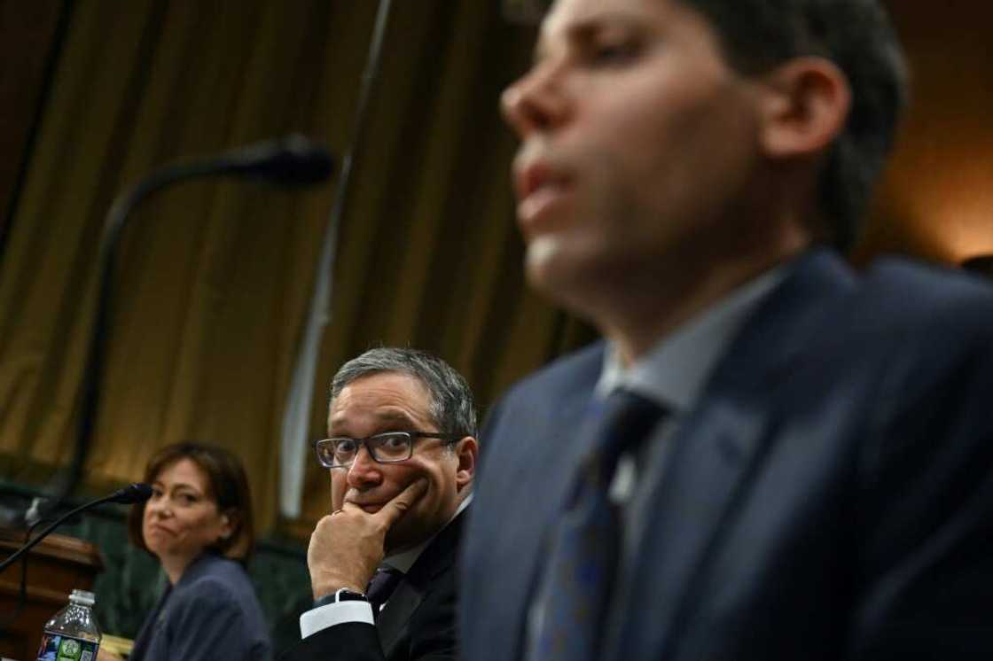 Christina Montgomery, Chief Privacy and Trust Officer at IBM, and Gary Marcus, Professor Emeritus at New York University, look on as Samuel Altman, CEO of OpenAI, testifies during a Senate Judiciary panel