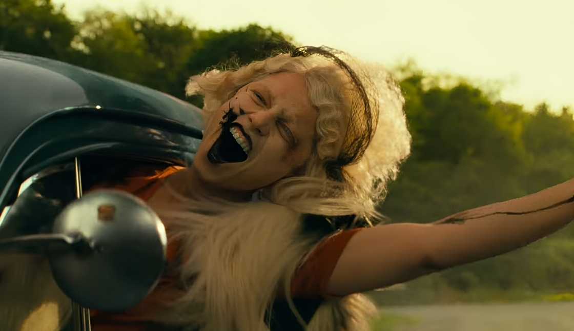Jessie Buckley riding in a car in a still from The Bride!