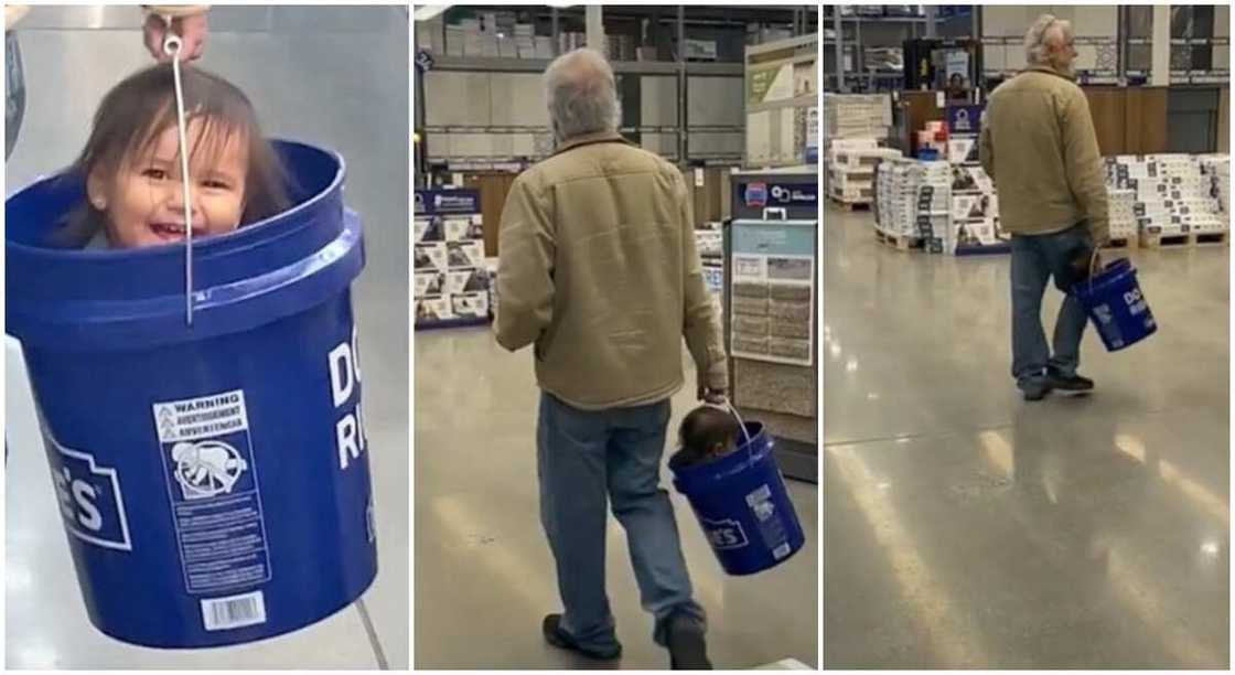 The man carries the baby inside a blue bucket while strolling in a store. The man carries the baby inside a blue bucket while strolling in a store.