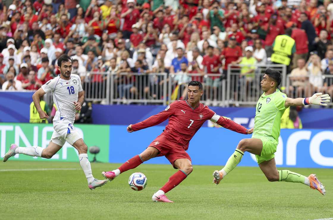 Cristiano Ronaldo shoots at goal blocked by Abduvohid Nematov during Portugal and Uzbekistan match. Photo by Alex Pantling Cristiano Ronaldo shoots at goal blocked by Abduvohid Nematov during Portugal and Uzbekistan match. Photo by Alex Pantling