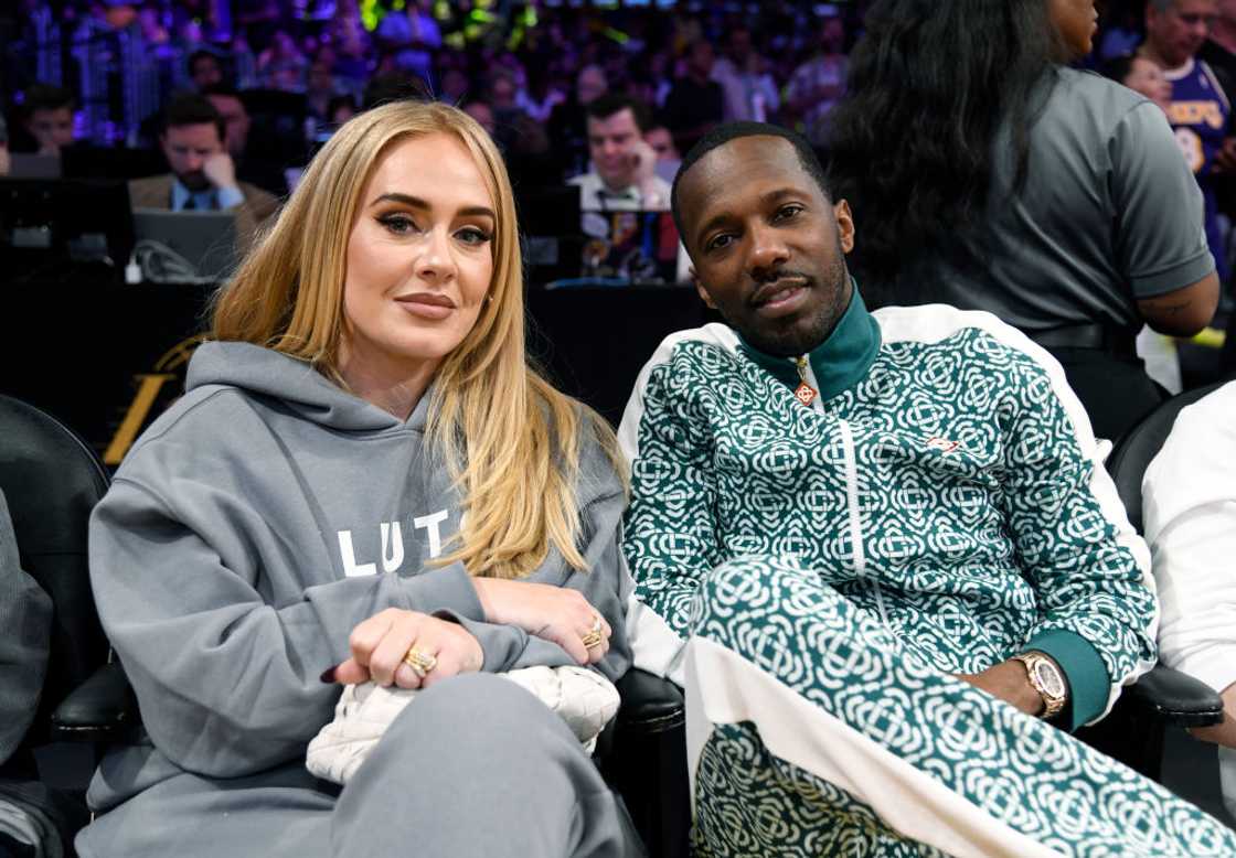 Adele and Rich Paul sit side by side at a basketball event