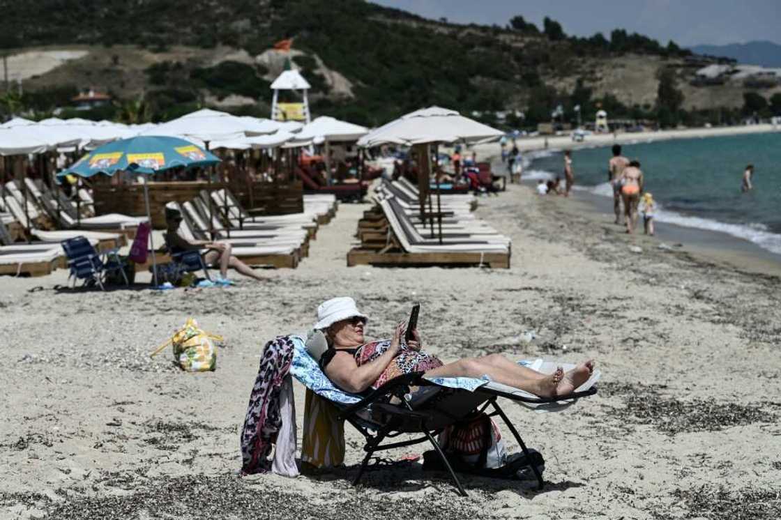 A woman enjoys the sun on a beach on Greece's Halkidiki peninsula A woman enjoys the sun on a beach on Greece's Halkidiki peninsula