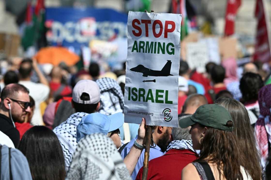 A protestor in Berlin holds a sign that reads 'Stop arming Israel'
