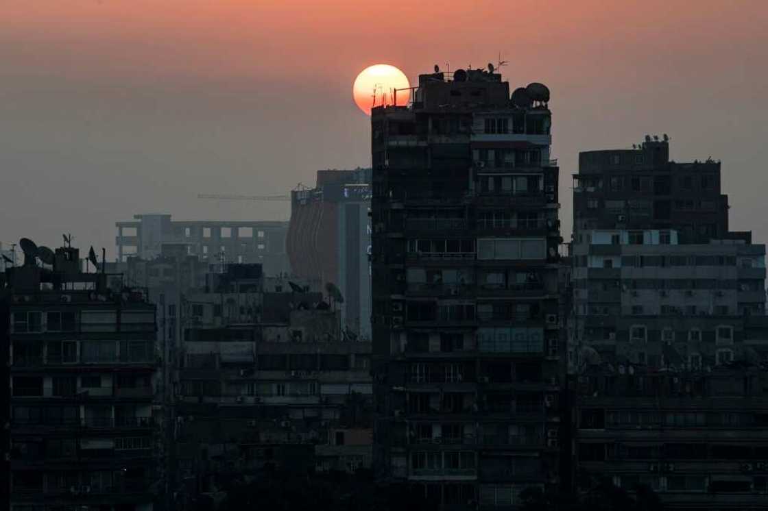 The sun rises behind the skyline of Egypt's capital Cairo and its Nile river island of Manial