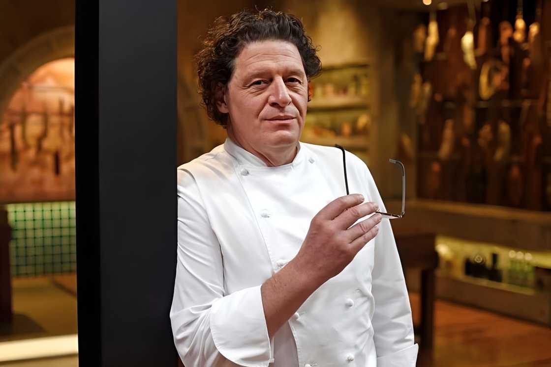 Marco Pierre White poses leaning against a beam