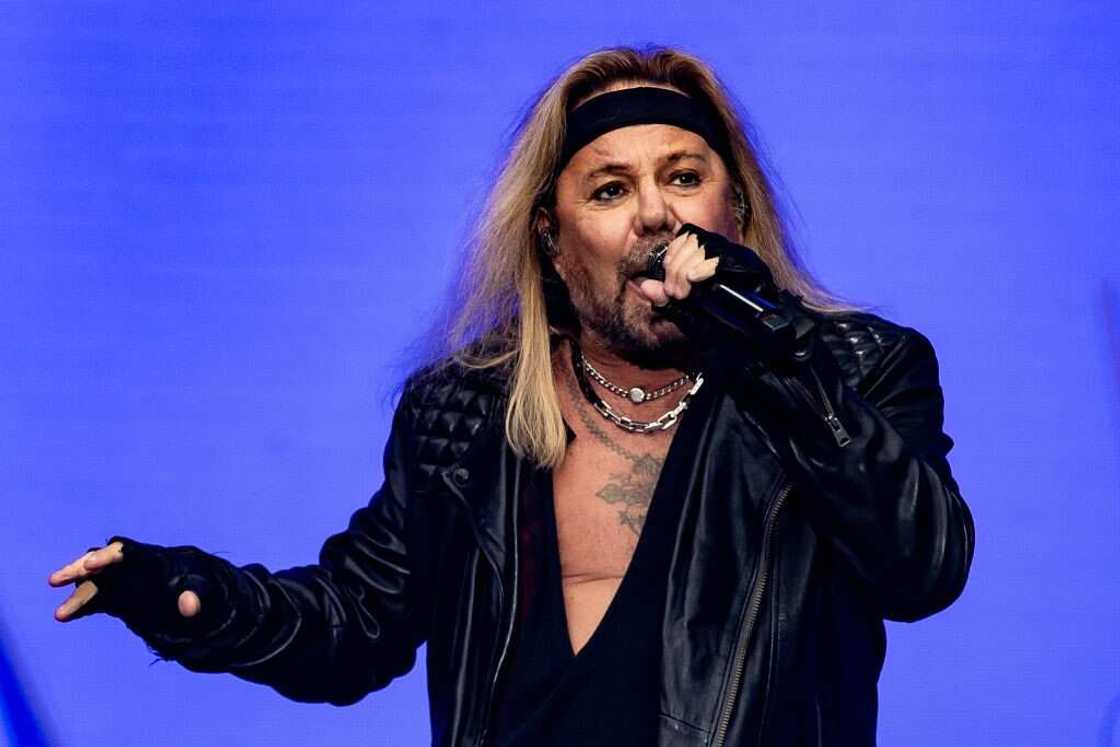 Vince Neil performs on stage in a black outfit Vince Neil performs on stage in a black outfit