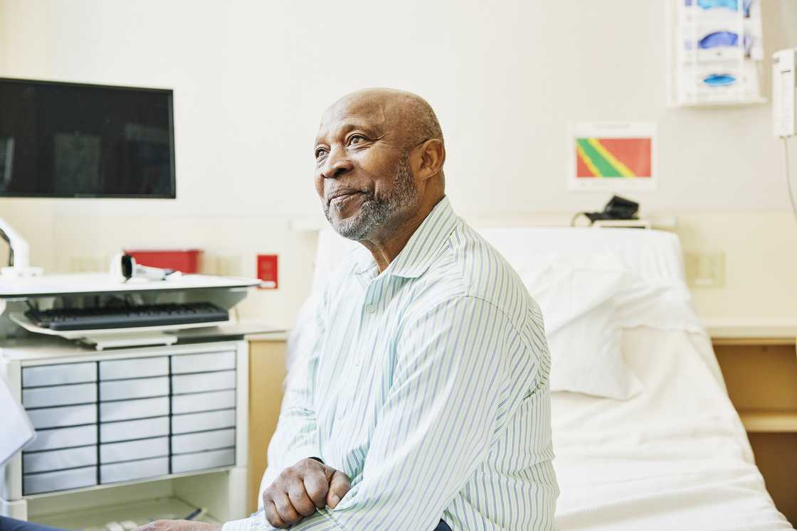A man sitting in a hospital bed smiling
