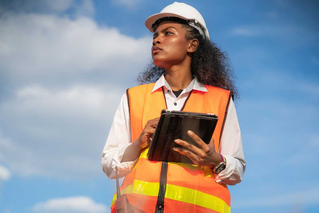 A young lady holding a notepad is out working in the field A young lady holding a notepad is out working in the field