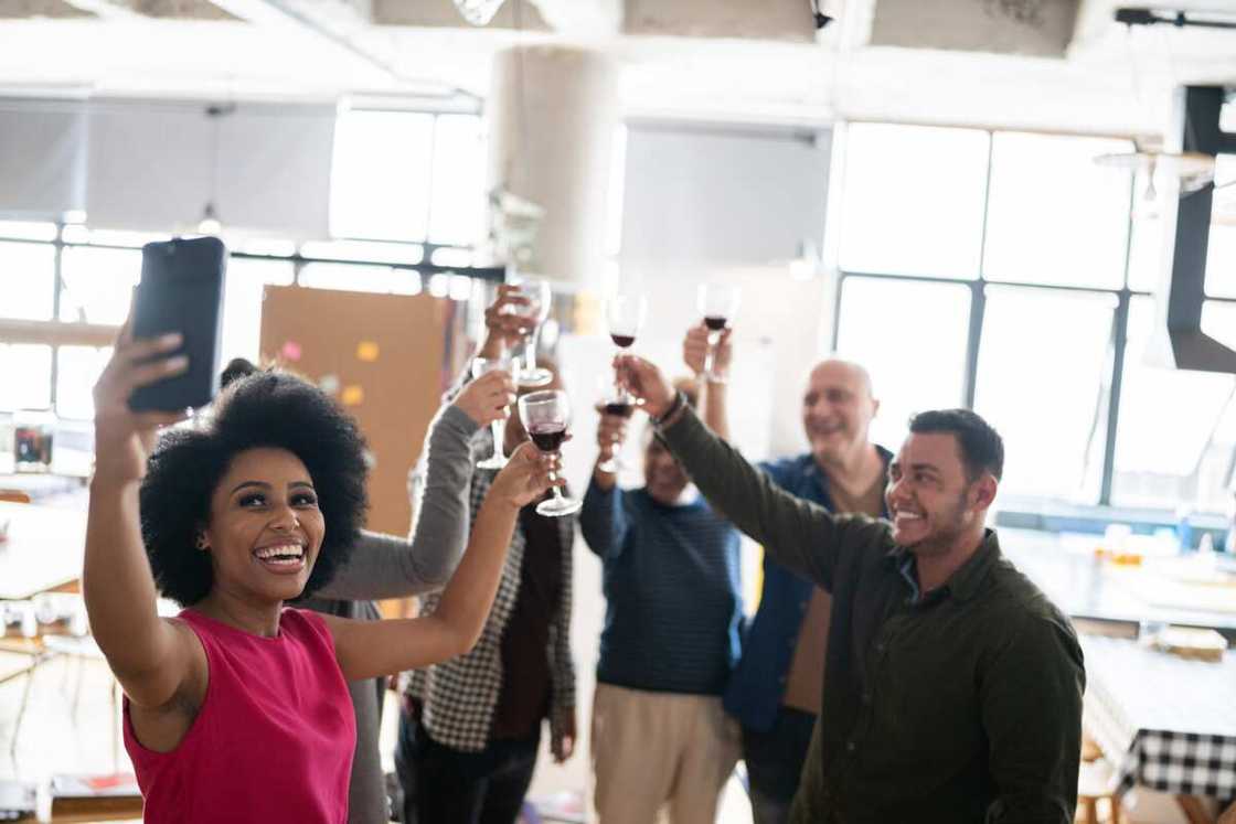Colleagues having a video call while toasting Colleagues having a video call while toasting